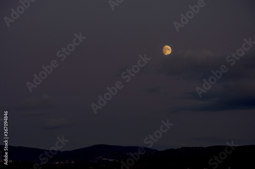 Dark evening landscape with shining full moon. Shining full moon on the sky.