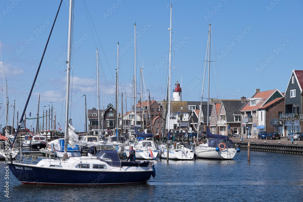 Harbor of small fishing town Urk west harbour with fishing and sailing boats and lighthouse. Historical center former island of Urk alongside the IJsselmeer