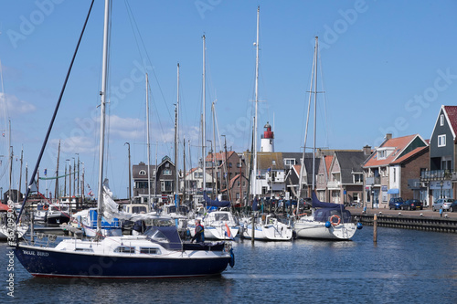 Harbor of small fishing town Urk west harbour with fishing and sailing boats and lighthouse. Historical center former island of Urk alongside the IJsselmeer