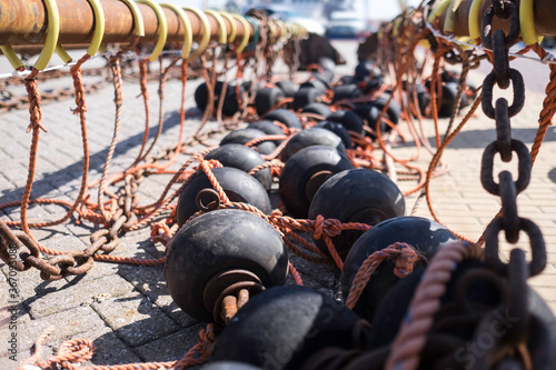Photos Bobbins and floats for bottom trawling with a trawl fishing net, drying on a str