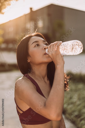 Fitness woman drinking water from bottle.