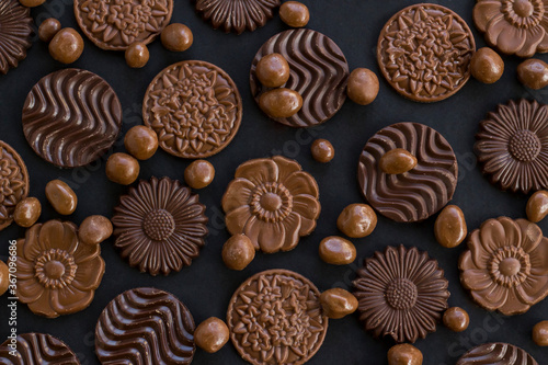 Milky and bitter round shape chocolate Madlen,designed on black background with dark ball chocolates.The Sugar Feast or any festival celebration.Top view.