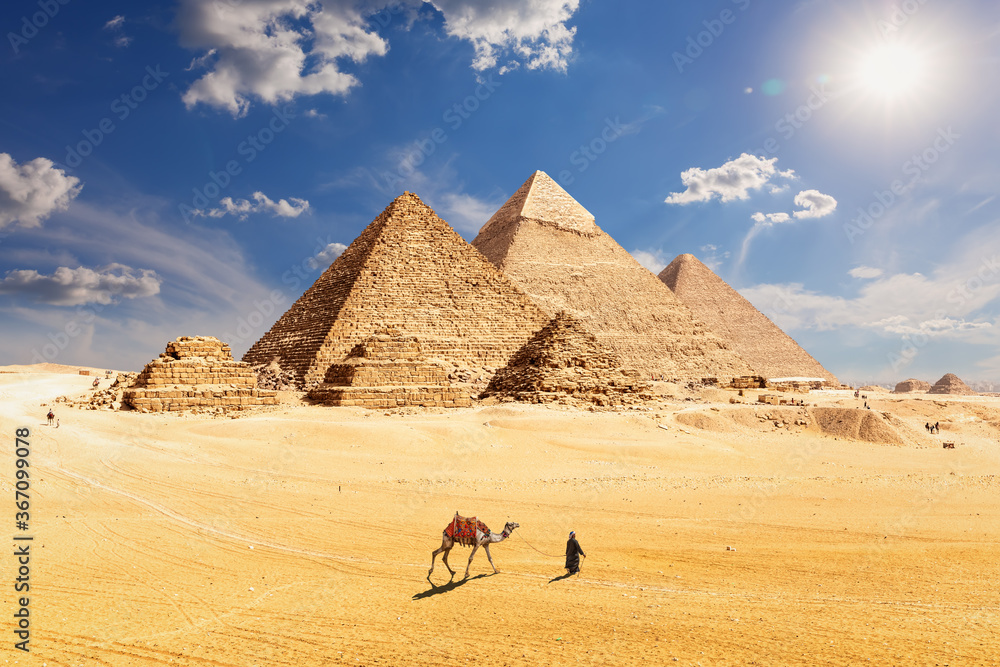 Famous Pyramids of Egypt and a bedouin with a camel, Giza, Cairo