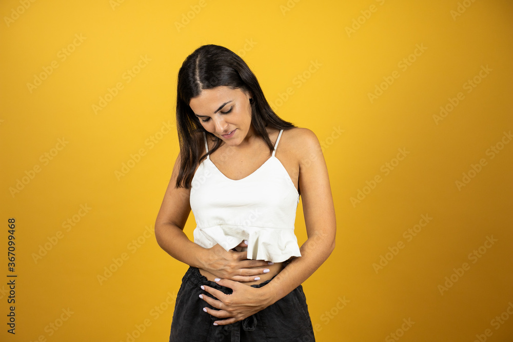 Obraz premium Young beautiful woman pregnent putting her hands on her belly and looking at it with Love. New born