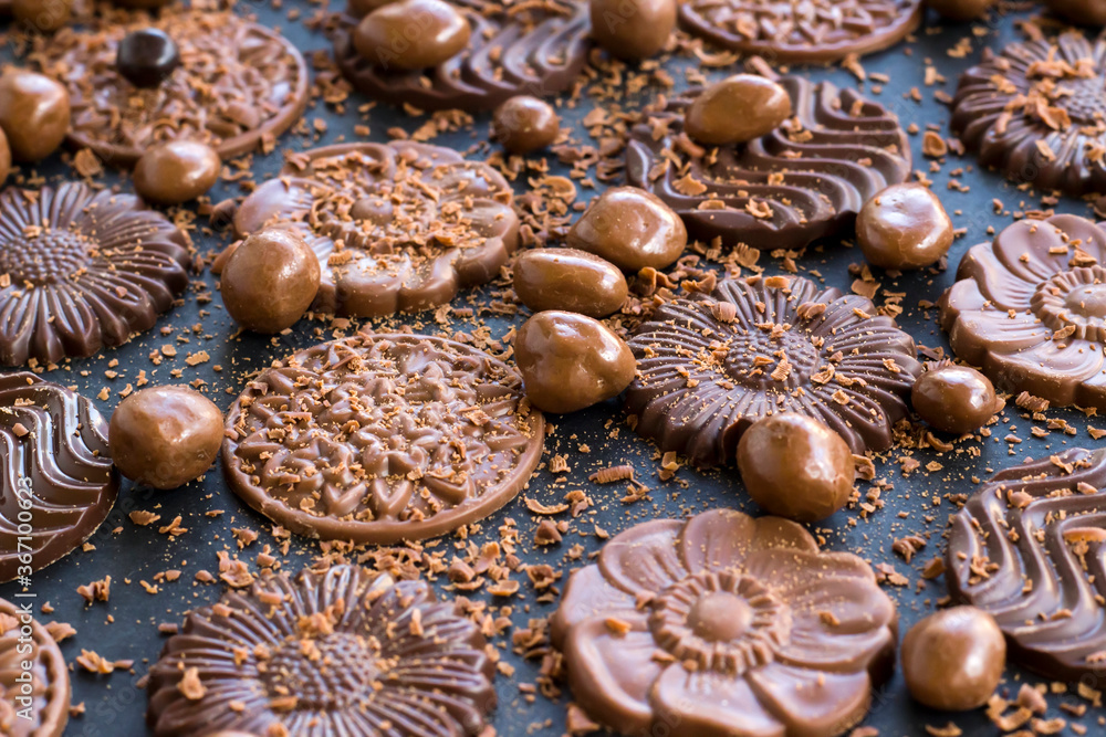 Milky and bitter round shape chocolate Madlen,designed on black background with ball chocolate and grains. Milky and bitter round shape chocolate Madlen,designed on black background with ball chocolate and grains.