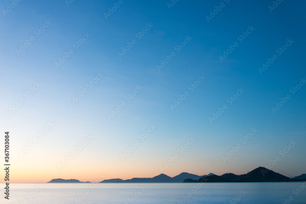 Tropical mountains across the ocean at sunrise