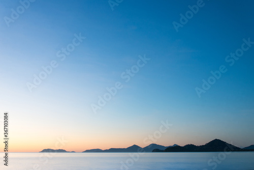 Tropical mountains across the ocean at sunrise