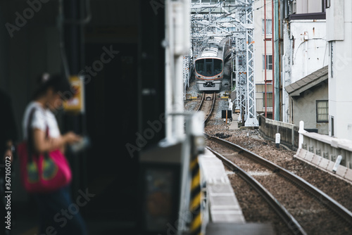 Woman waiting on platform with train arriving 