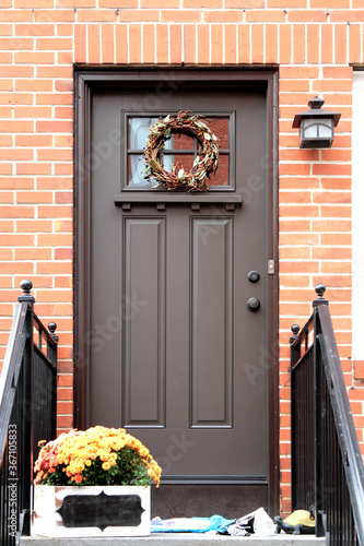 Brown vintage entry door in New York decorated with wreath. USA.