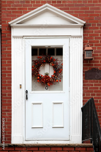 White vintage entry door decorated with Halloween wreath. New York. USA.