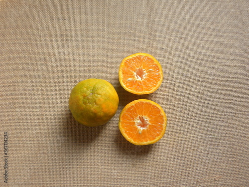 Whole and cut ripe Nagpur orange fruits photo