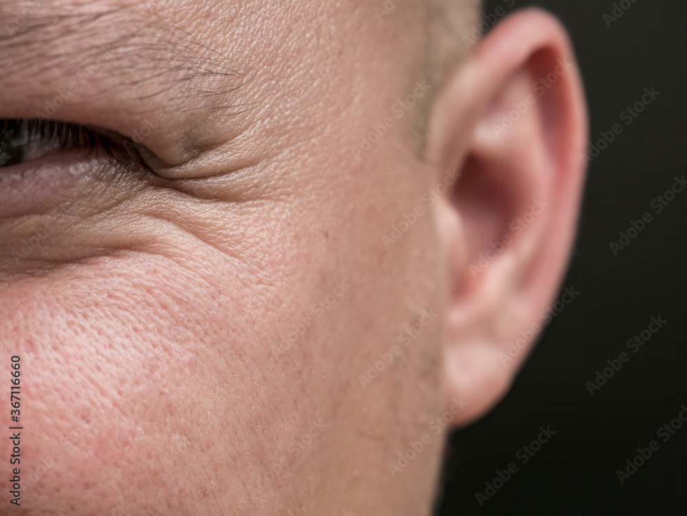 Obraz premium Male eye frowning. Close up of a man's eye with wrinkles.