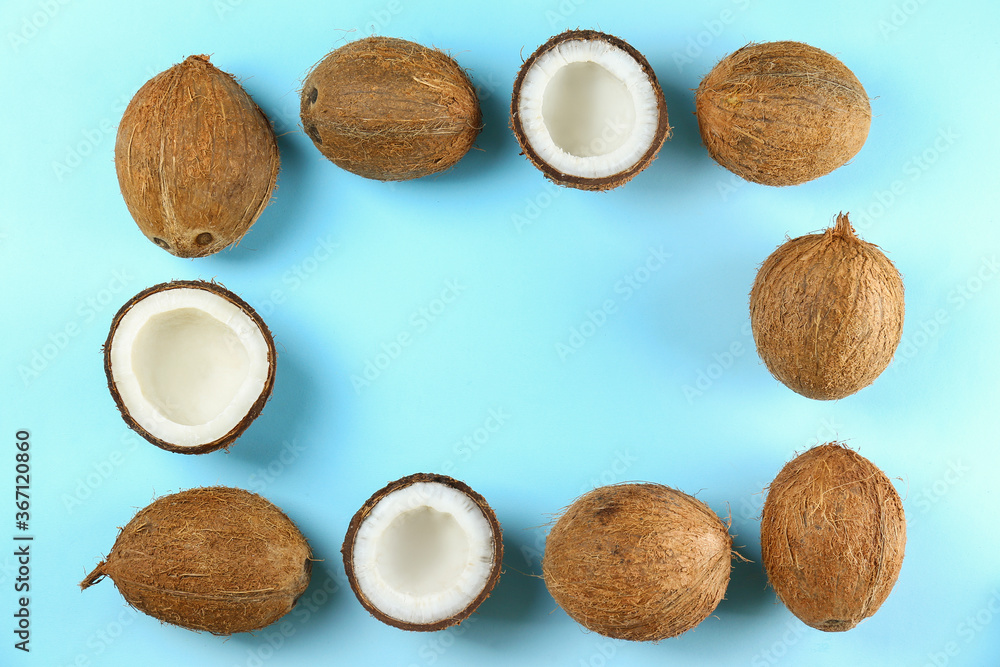 Top view shot of coconuts, whole and cracked on halves on paper textured background with a lot of copy space for text. Background with raw fruit of tropical palm. Flat lay.b Top view shot of coconuts, whole and cracked on halves on paper textured background with a lot of copy space for text. Background with raw fruit of tropical palm. Flat lay.b