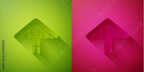 Paper cut Hang glider icon isolated on green and pink background. Extreme sport. Paper art style. Vector Illustration.