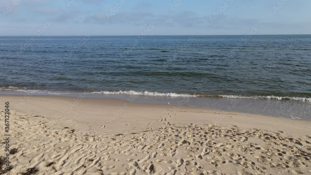 Flight over the beach Aerial view of the gentle waves crashing on the sandy beach by the Baltic Sea Flight over the beach Aerial view of the gentle waves crashing on the sandy beach by the Baltic Sea