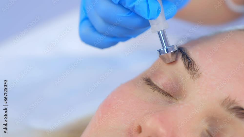 Microcurrent face treatment with hyaluronic acid gel for young woman in