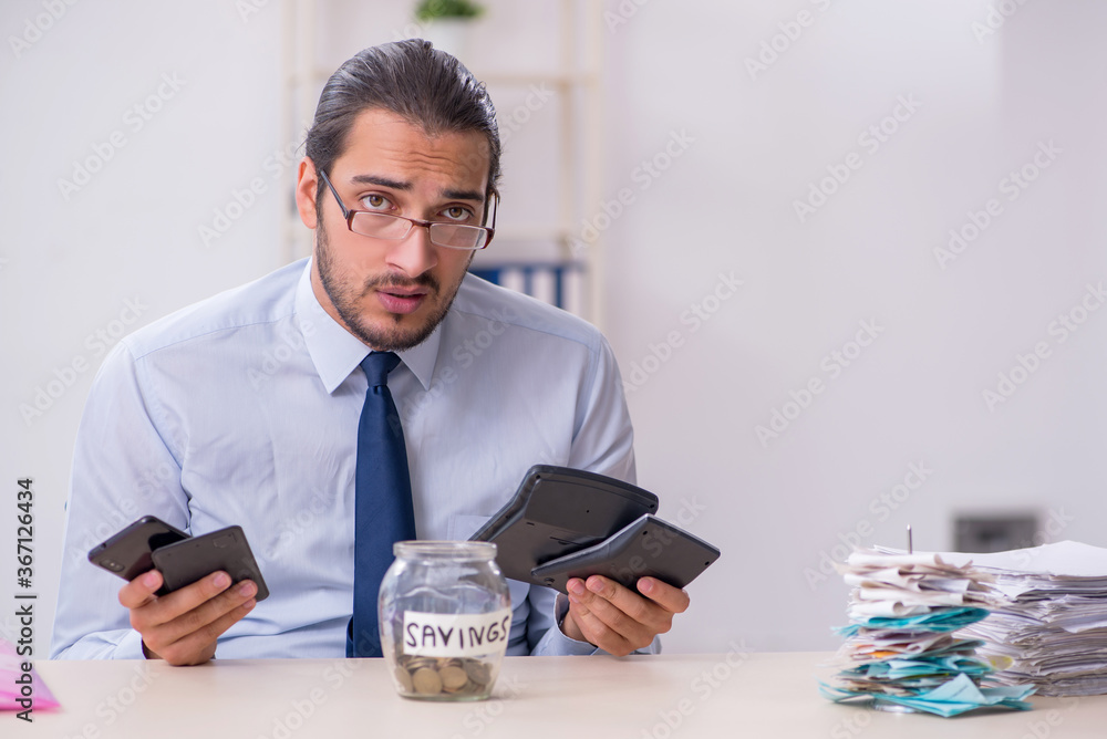 Young male employee in budget planning concept Young male employee in budget planning concept