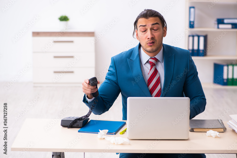Sick male employee suffering at workplace from coronavirus Sick male employee suffering at workplace from coronavirus