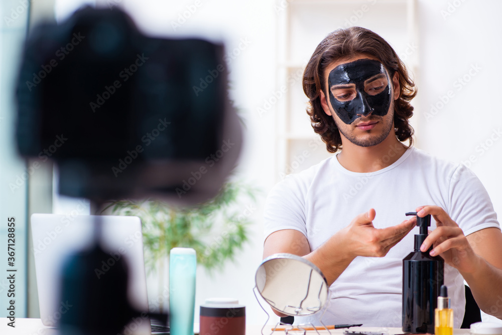Young male cosmetician recording video for his blog Young male cosmetician recording video for his blog