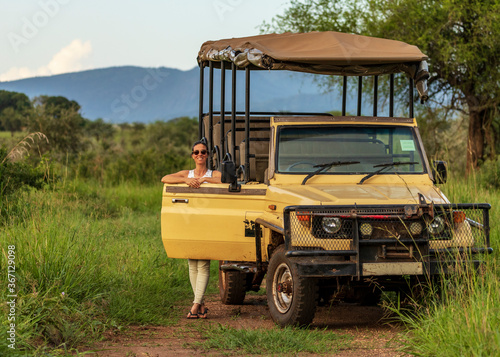 Girl standing close to a safari car, during a coffee stop of a safari drive in the wilderness of Africa