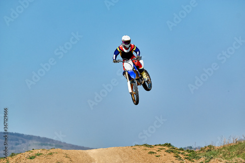 Fototapeta Naklejka Na Ścianę i Meble -  motocross rider jumping on a motorcycle