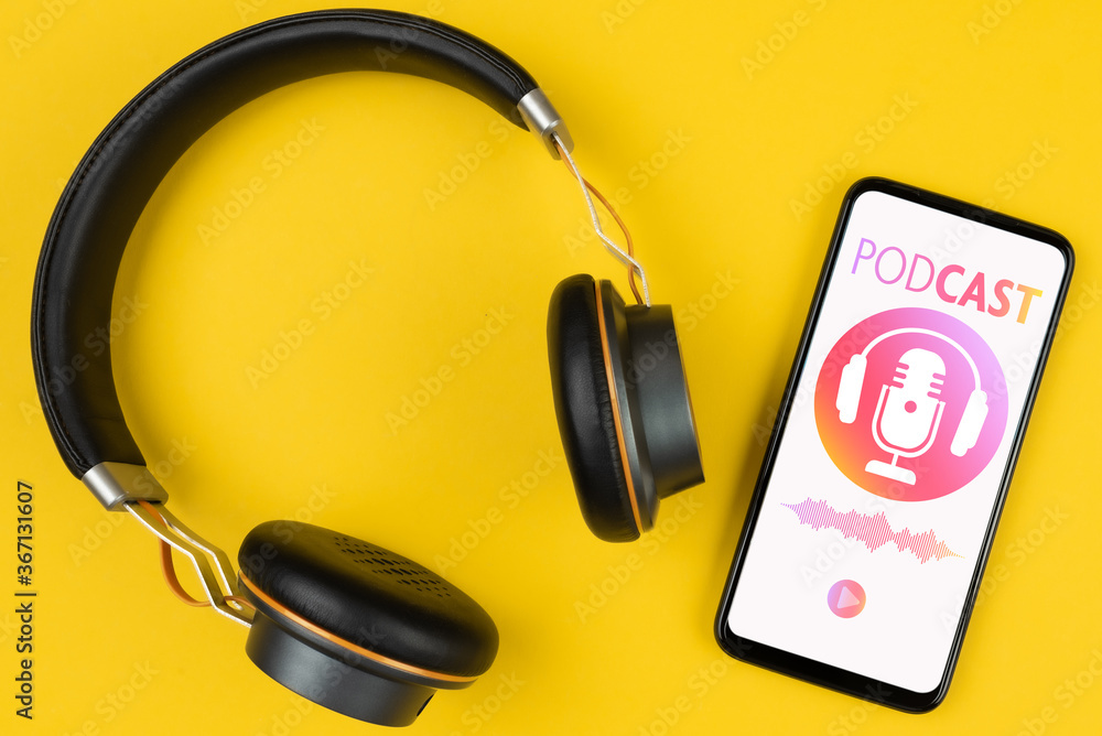 podcasting concept, above view of headphones and smartphone with podcast player mockup on yellow background podcasting concept, above view of headphones and smartphone with podcast player mockup on yellow background