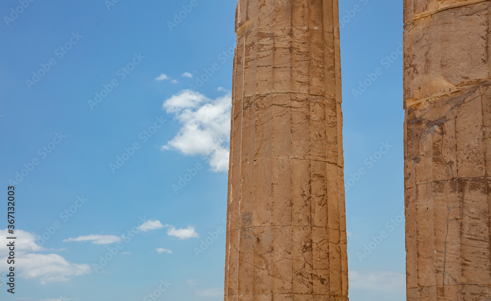 Athens, Greece. Propylaea columns in the Acropolis, blue cloudy sky in spring sunny day.