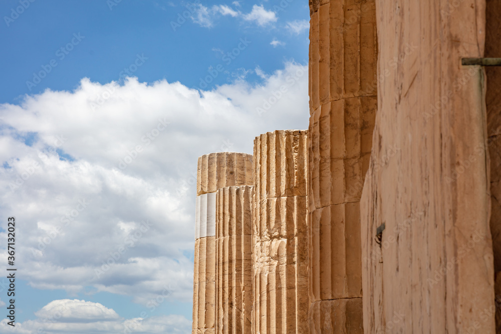 Athens, Greece. Propylaea columns in the Acropolis, blue cloudy sky in spring sunny day. Athens, Greece. Propylaea columns in the Acropolis, blue cloudy sky in spring sunny day.