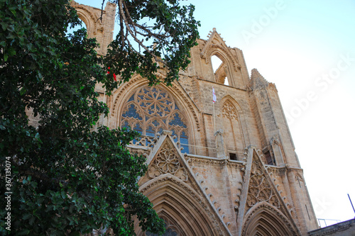 View from below through the trees on the facade of the Lala Mustafa Pasha Mosque (former St. Nicholas Cathedral). Famagusta. Cyprus. photo