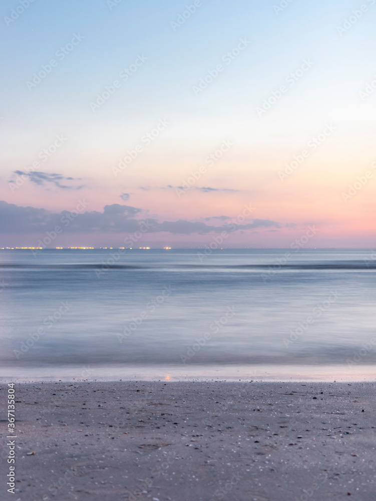 Evening at the beach with a long exposure shot of the ocean making it look soft. Evening at the beach with a long exposure shot of the ocean making it look soft.