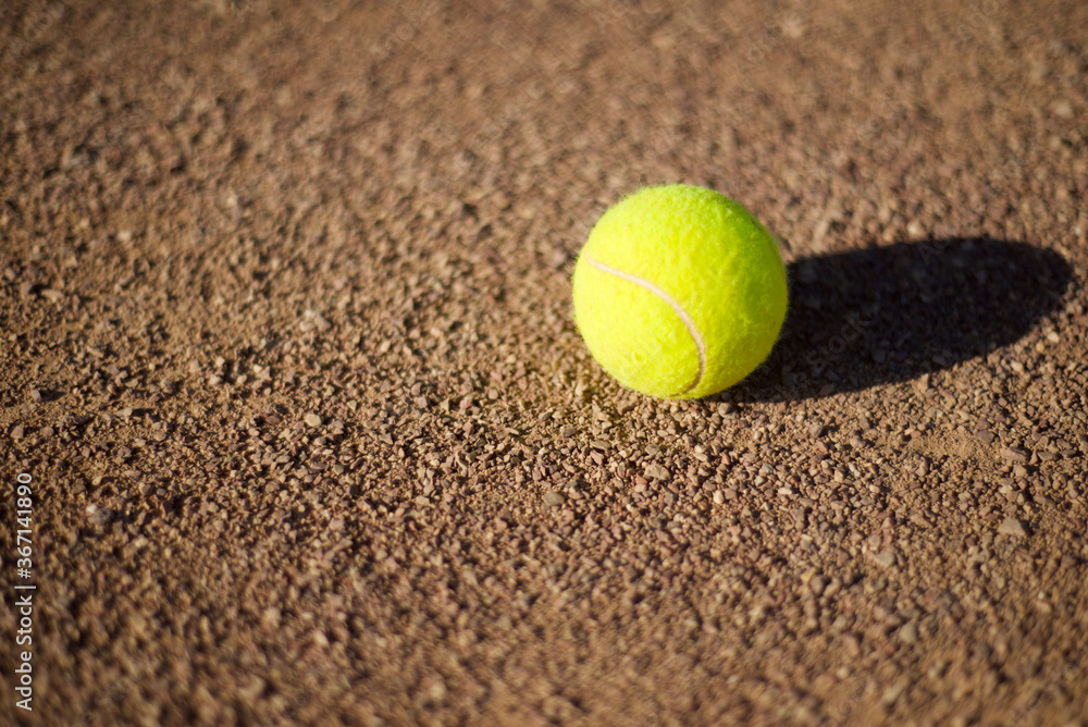  Tennis ball on a clay court. Copy space for text.
