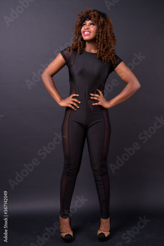 Young beautiful African woman against black background © Ranta Images