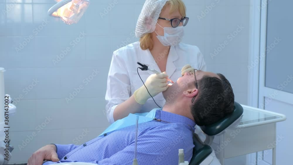 Dentist examining gums of patient with a probe and needle using method