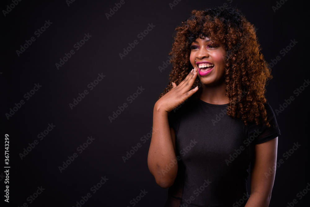Young beautiful African woman against black background Young beautiful African woman against black background
