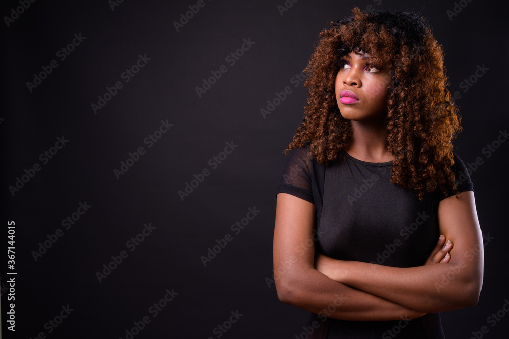 Fototapeta premium Young beautiful African woman against black background