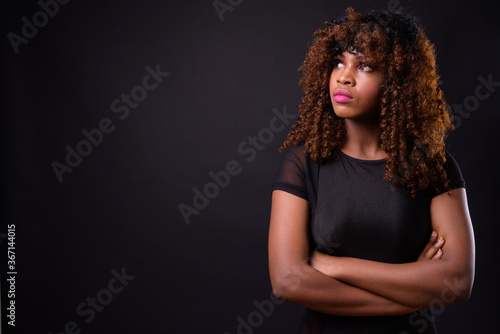 Young beautiful African woman against black background