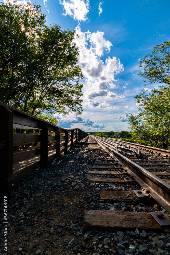 a view of the railway tracks and the pedestrian walkway on a train bridge that spans the South Saskatchewan River in Saskatoon, Saskatchewan Canada  