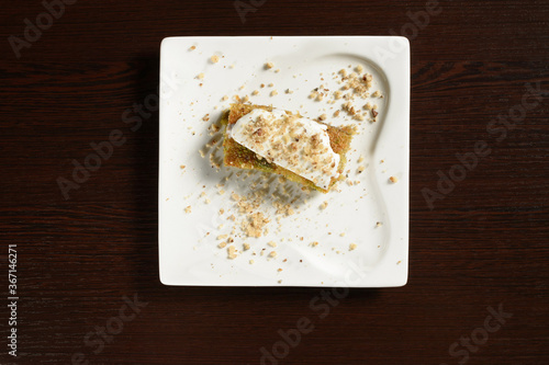 Pistachio Turkish baklava with ice cream on a square plate, top view. Photos for restaurant and cafe menus