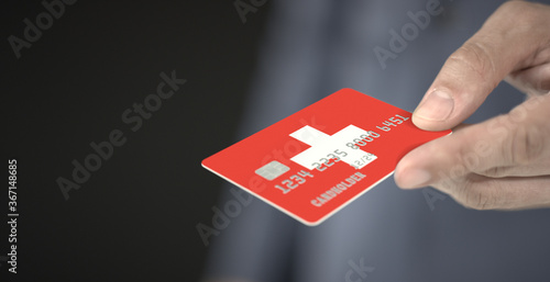 Unknown man gives credit card with printed flag of Switzerland. Fictional numbers