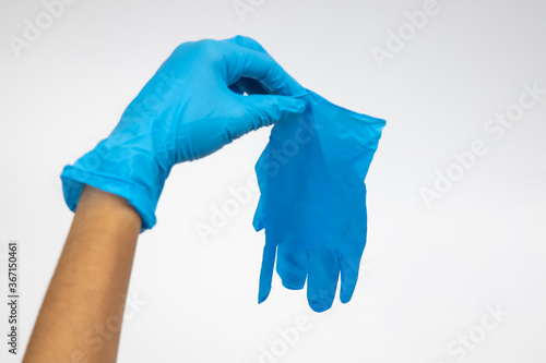 Female hand wears a protective glove for cleaning or tidying. Woman's hand latex glove gesture isolated on white. Female hand putting on latex glove isolated on white background