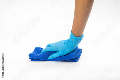Close up of hands in rubber protective blue gloves cleaning the blue surface with a rag. Home, housekeeping concept