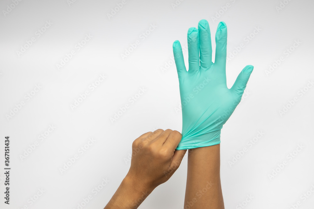 Female hand wears a protective glove for cleaning or tidying. Woman's hand latex glove gesture isolated on white. Female hand putting on latex glove isolated on white background