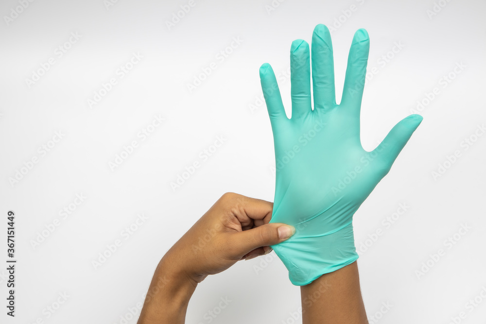 Female hand wears a protective glove for cleaning or tidying. Woman's hand latex glove gesture isolated on white. Female hand putting on latex glove isolated on white background Female hand wears a protective glove for cleaning or tidying. Woman's hand latex glove gesture isolated on white. Female hand putting on latex glove isolated on white background