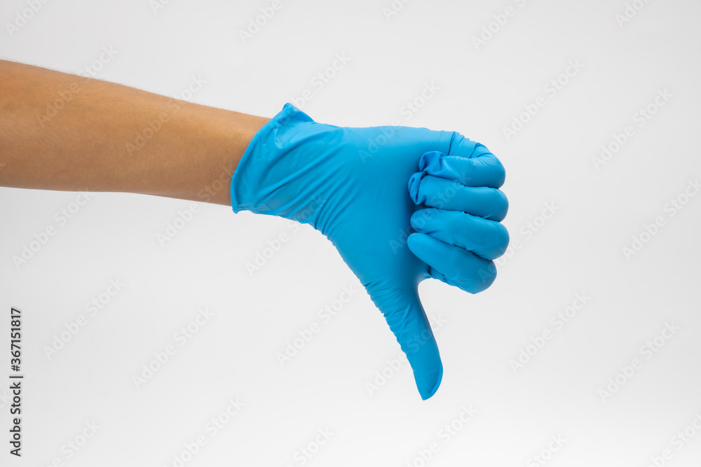 Hand of surgeon in blue medical glove showing Ok sign, isolated on a white background Hand of surgeon in blue medical glove showing Ok sign, isolated on a white background