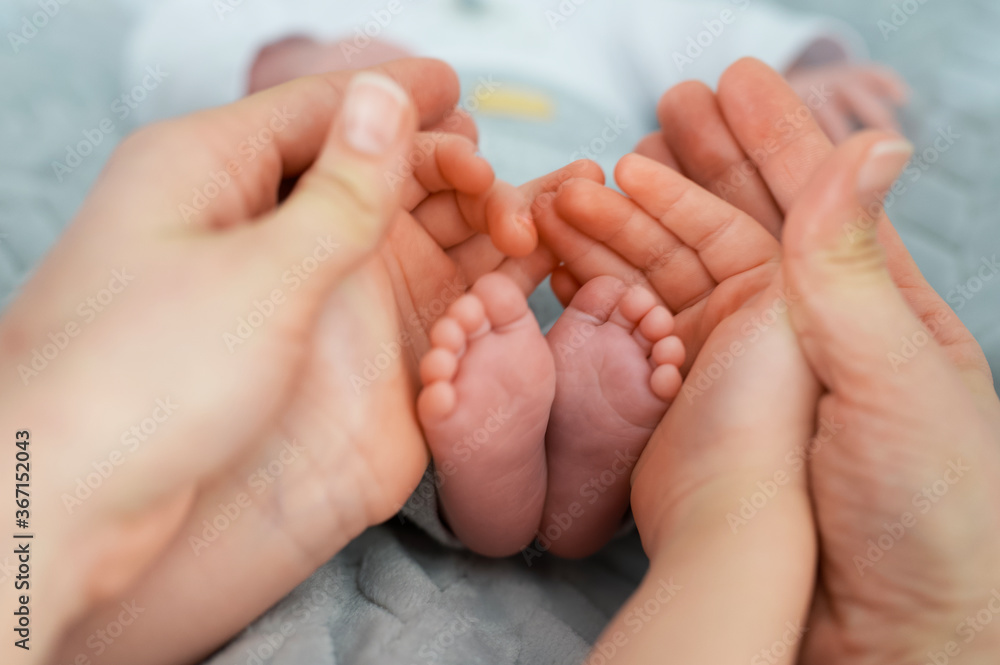 Selective focus shot of newborn baby's feet with hands around it Selective focus shot of newborn baby's feet with hands around it