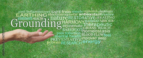 Grounding earthing Word Tag Cloud - female hand palm up outstretched with the word GROUNDING floating above surrounded by a relevant word cloud on a green grass background photo