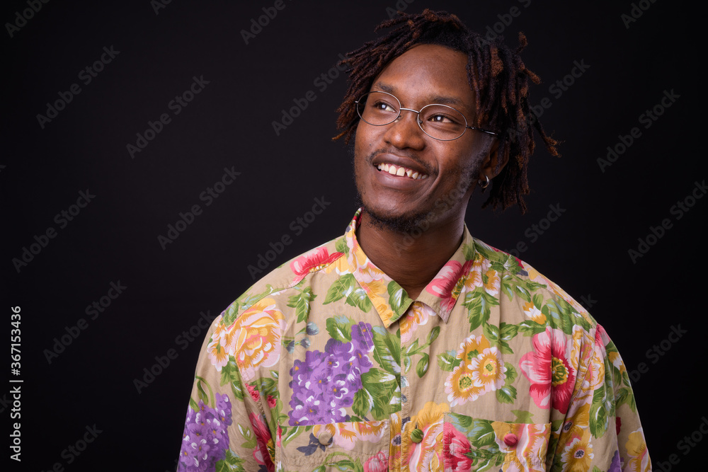 Young African man with dreadlocks against black background Young African man with dreadlocks against black background