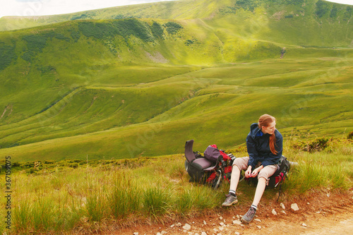 Wallpaper Mural Young blonde woman tourist resting on a hiking backpack in the mountains Torontodigital.ca