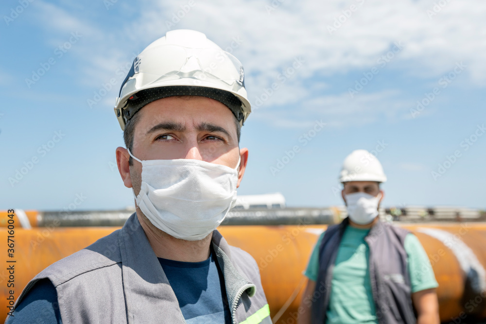 The workers are using protective masks for pandemic of the coronavirus (covid-19) in the construction site. The workers are using protective masks for pandemic of the coronavirus (covid-19) in the construction site.