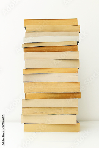 Stack of paperback books against white background with only the pages showing.